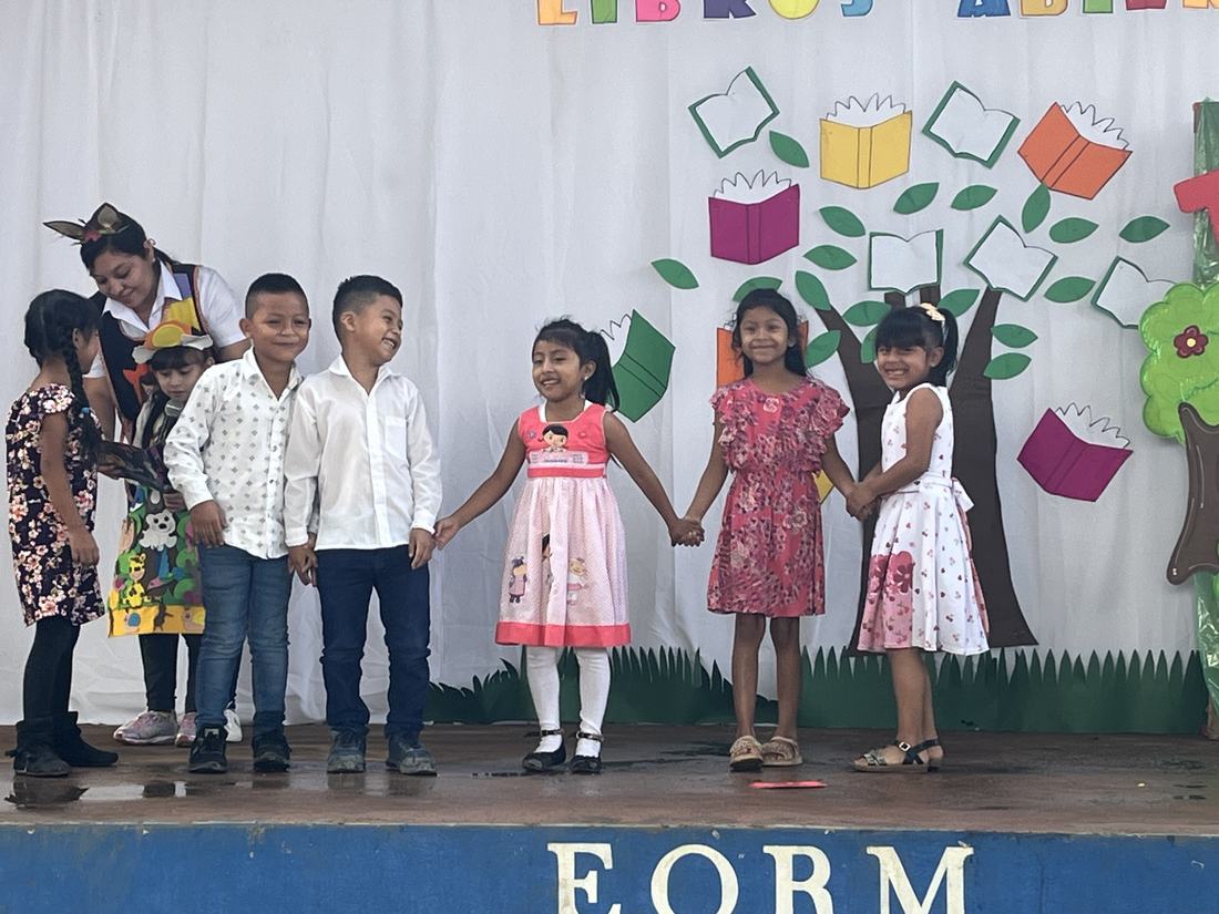 Students holding hands on stage at Sarbelio Morán Chinchilla Rural school